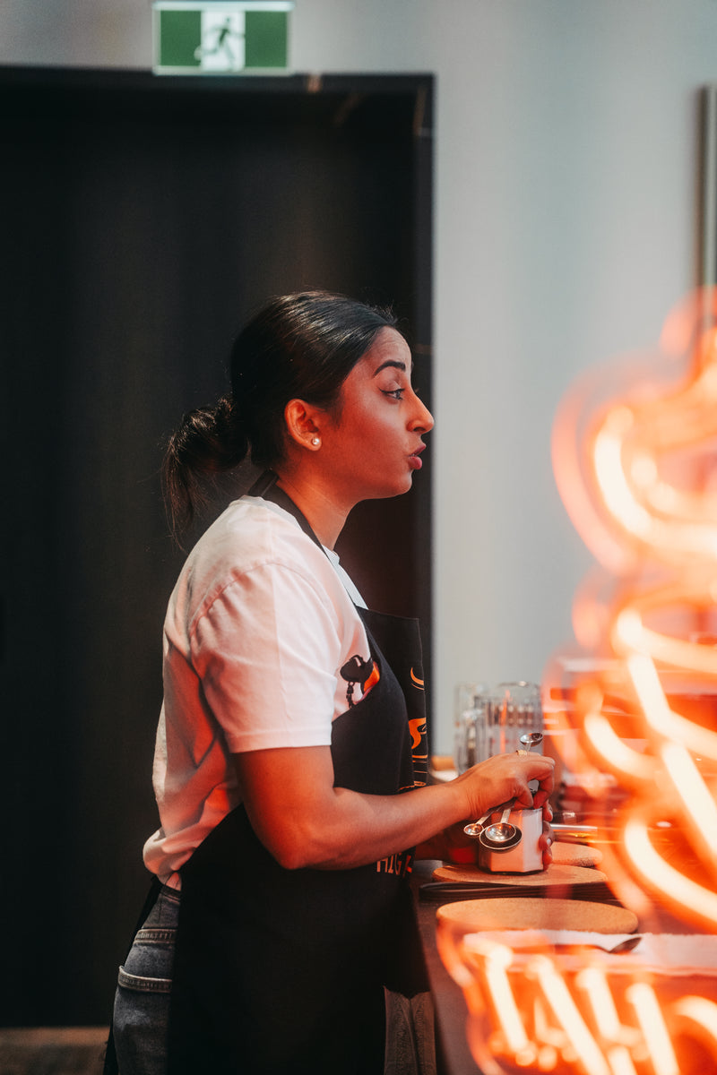 Person wearing an apron in a kitchen setting with a blurred background