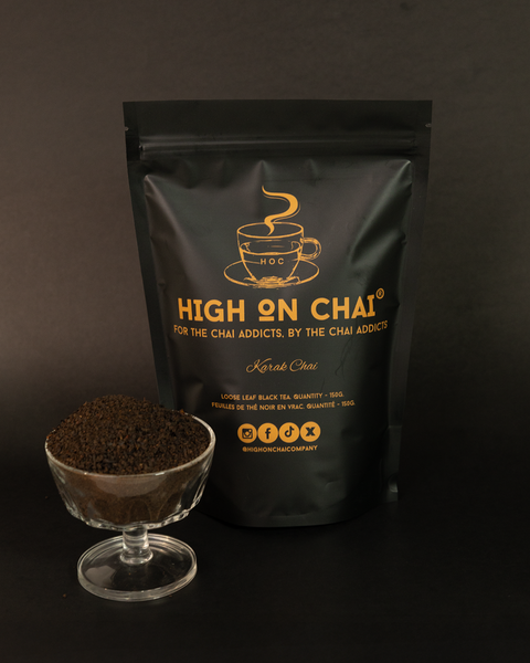 Black 'High on Chai' tea packaging with a glass of ground tea on a dark background